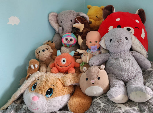 Toddler bed piled high with stuffed animals
