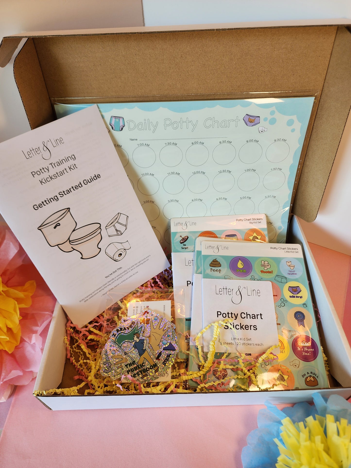 Open Potty Training Kickstart Kit box showing the potty chart, sticker packs, glitter stickers, and printed guide labeled “Getting Started.”