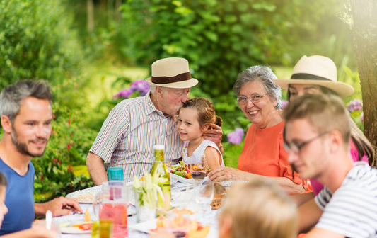Family gathering around an outdoor picnic table