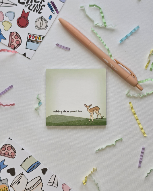 Wobbly Steps Count Too deer illustrated Post-it Note pad styled with a pen and colorful paper confetti on a white background