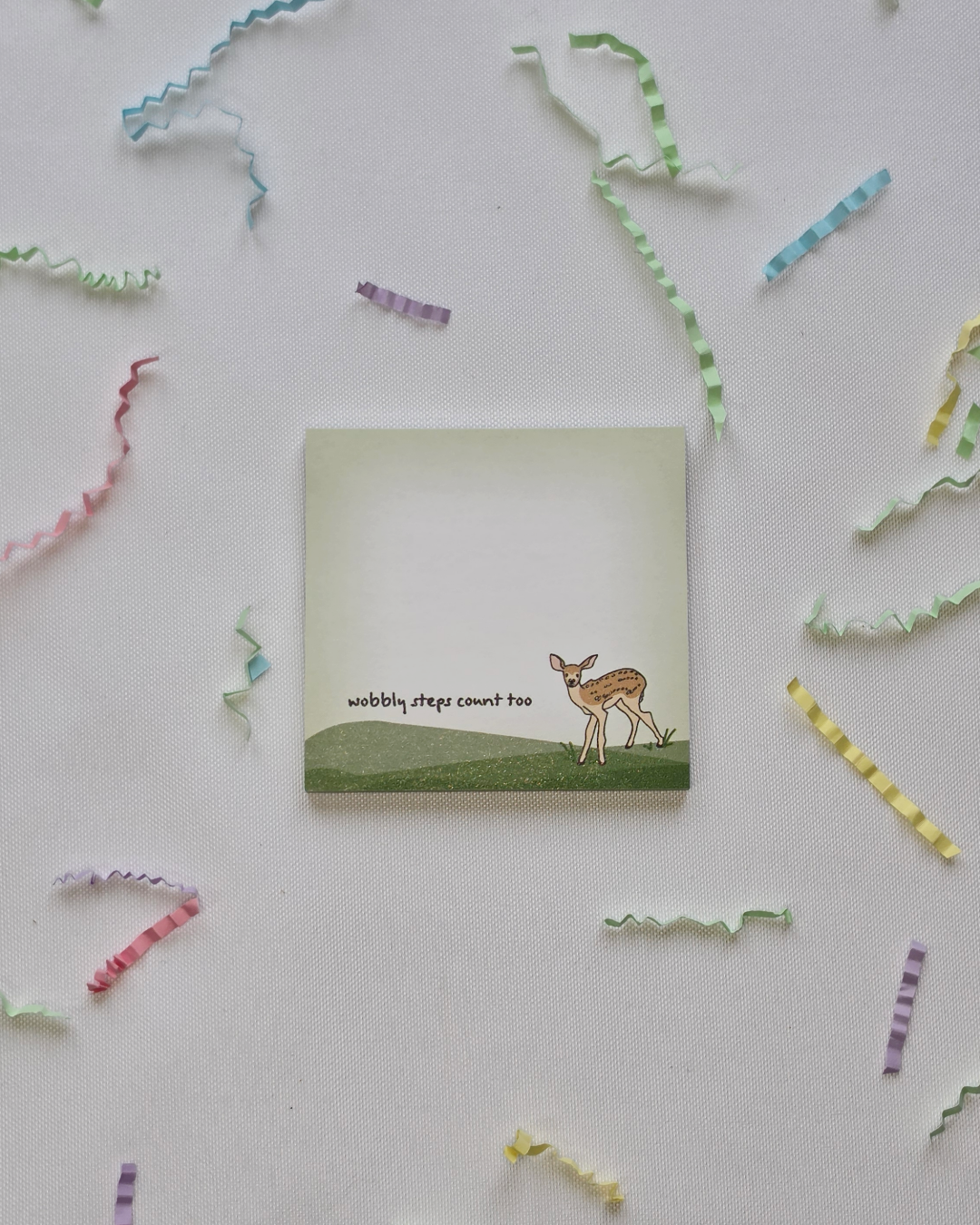 Wobbly Steps Count Too deer Post-it Note pad flat lay with scattered colorful paper strips