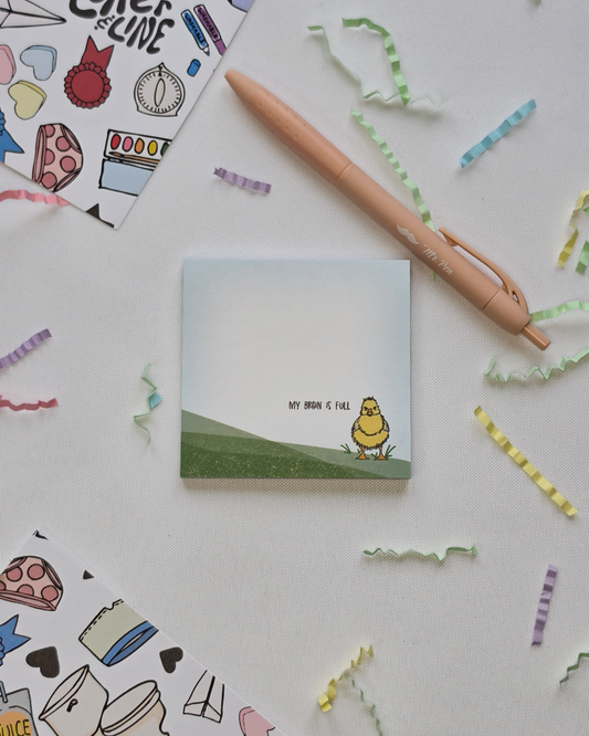 My Brain is Full duck illustrated Post-it Note pad styled with a pen and colorful paper confetti on a white background
