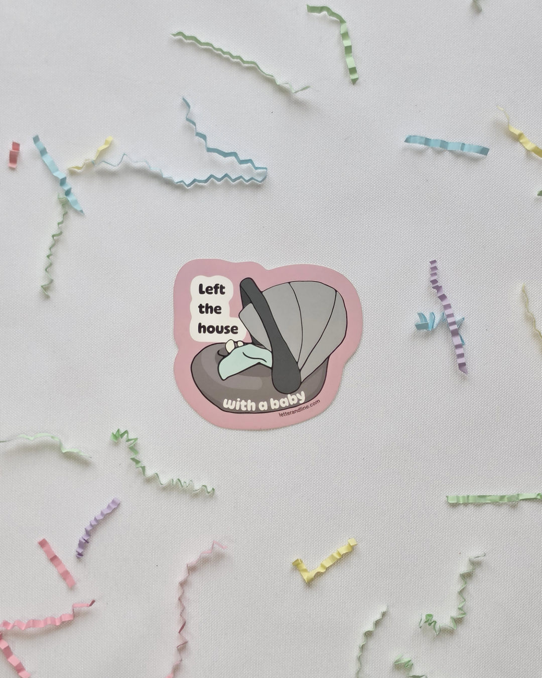 Left the House with a Baby milestone sticker flat lay with colorful paper confetti and baby items