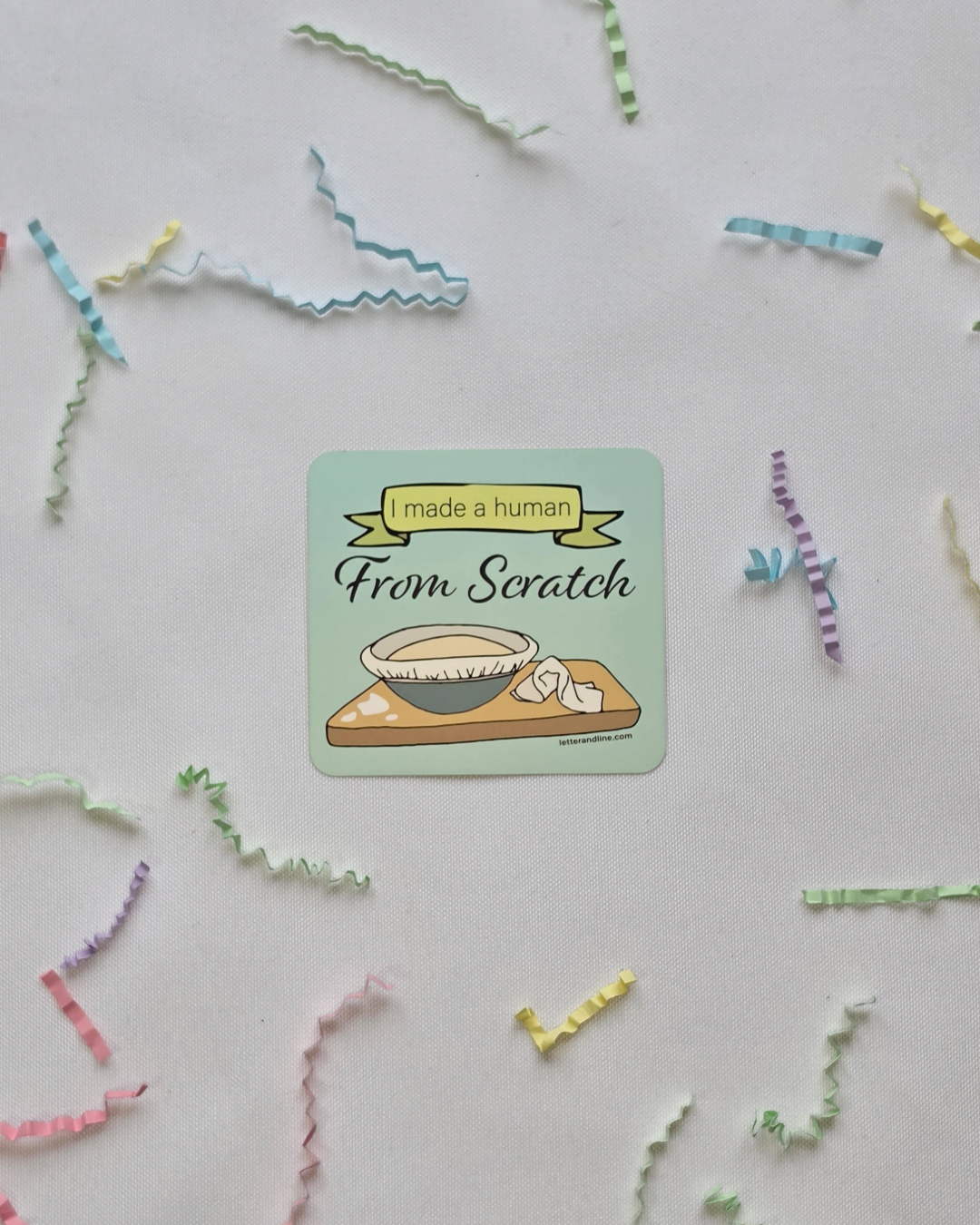I Made a Human From Scratch new parent milestone sticker flat lay with scattered colorful paper strips