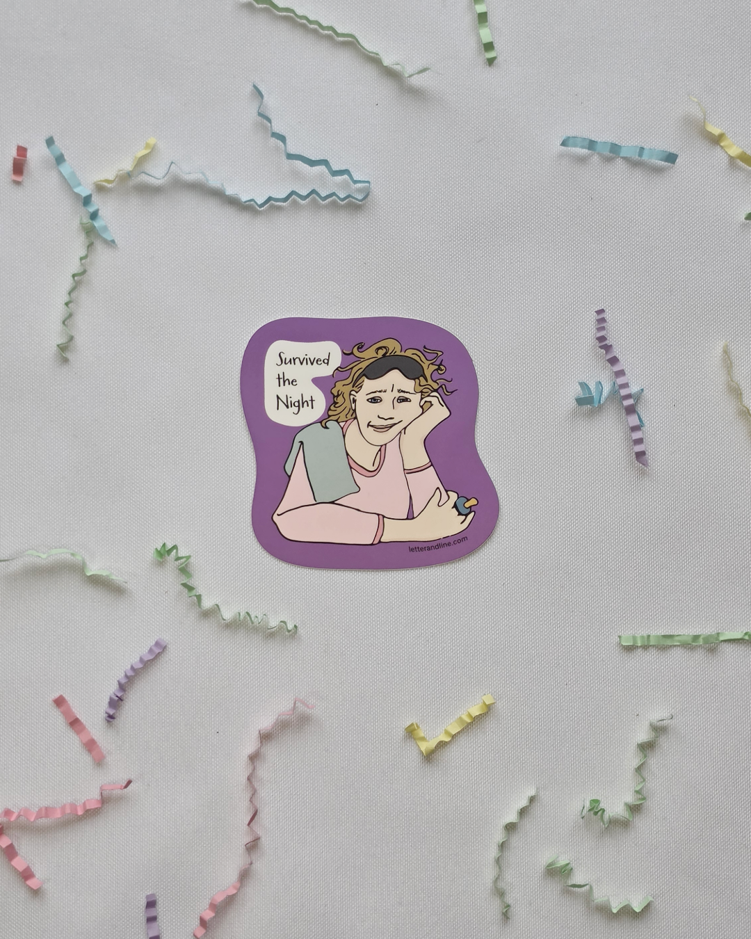 Survived the Night new parent milestone sticker flat lay with scattered colorful paper strips