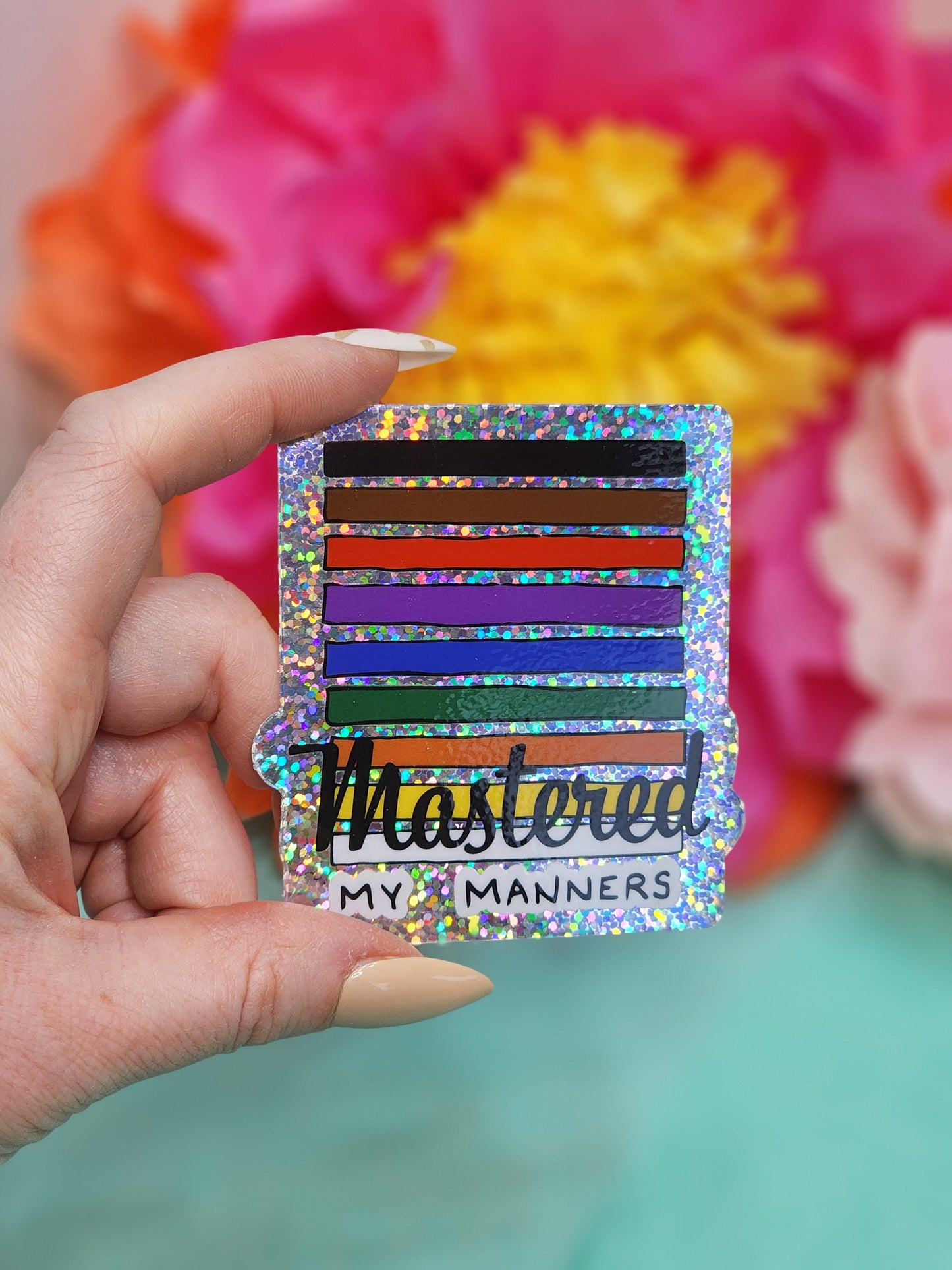 single “Mastered my Manners” glitter sticker held in hand, straight-on, showing holographic sparkle
